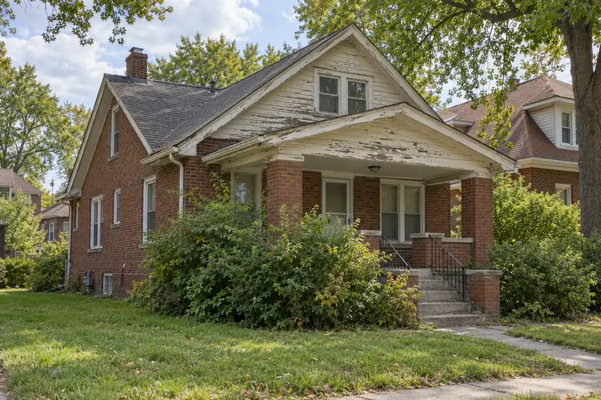 A house with peeling paint and worn roof shingles that needs repairs